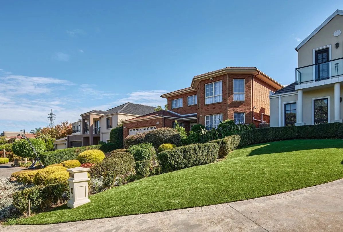 Freshly cut and edged front lawn with clipped hedges — real AOI job